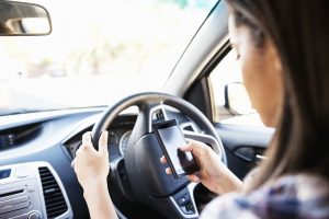 teenage girl Using Smart Phone While Driving Car