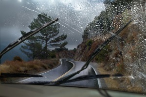 View behind windshield wiper in car with rain