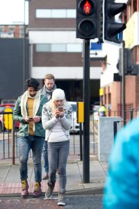 distracted pedestrians using mobile phones while crossing street