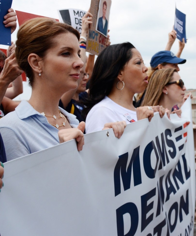 Shannon Watts of Moms Demand standing in protest line holding banner with others