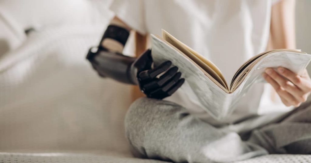 woman with artificial limb reading a book