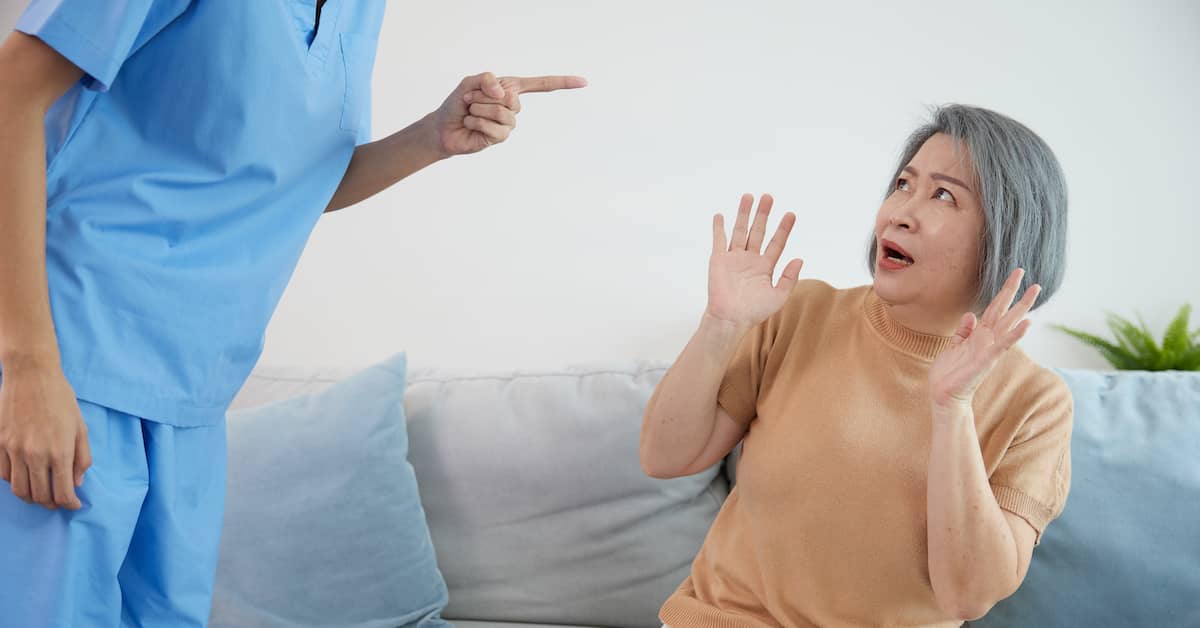 caregiver threatening an elderly woman in a nursing home