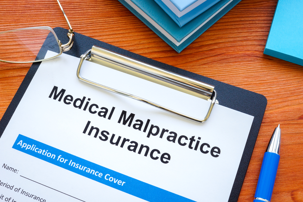Clipboard with medical malpractice insurance application, emphasizing the importance of professional liability coverage in healthcare.