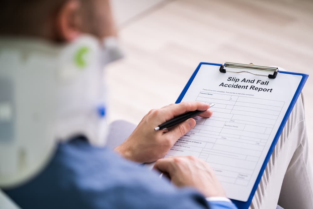 An individual with a broken arm filling out a health insurance claim form.