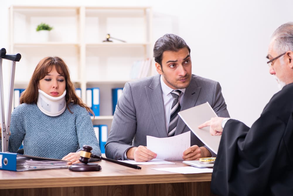 A young woman in a courthouse with a judge and a lawyer.