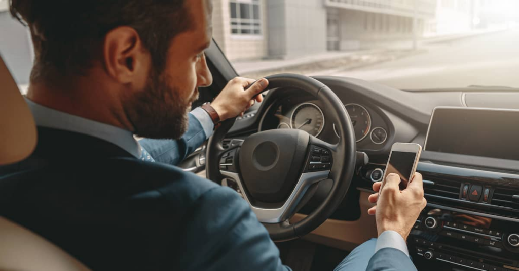 male driver distracted by texting behind the wheel