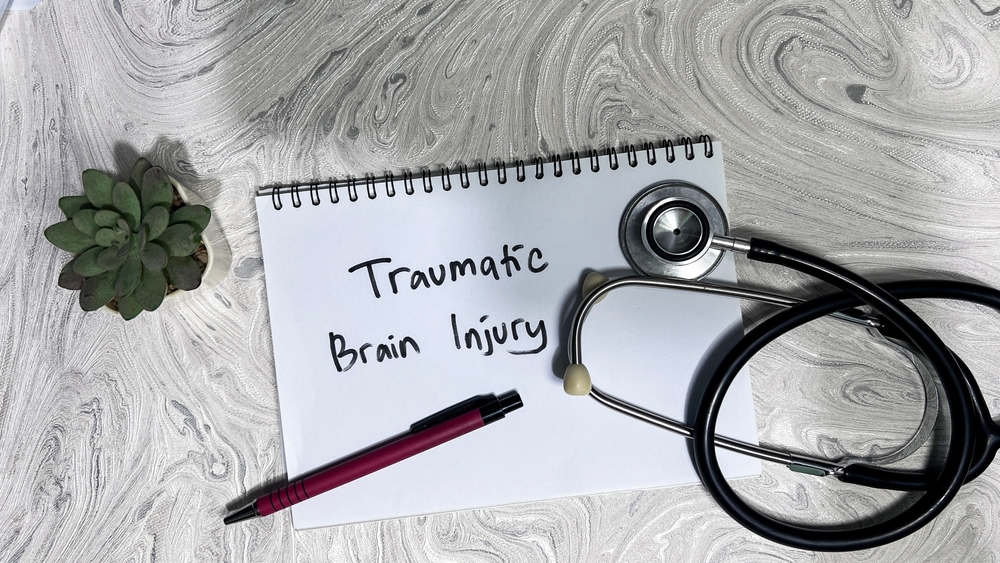 Notebook labeled traumatic brain injury with stethoscope representing medical care and Danbury traumatic brain injury attorney