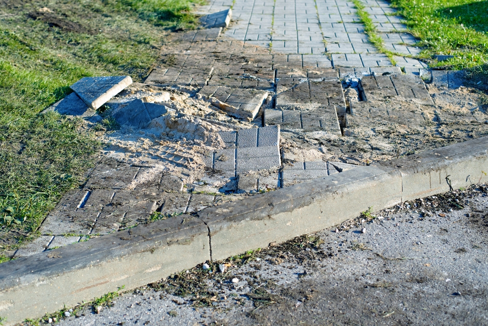 Broken uneven sidewalk with damaged pavement showing hazard relevant to Danbury slip and fall lawyer