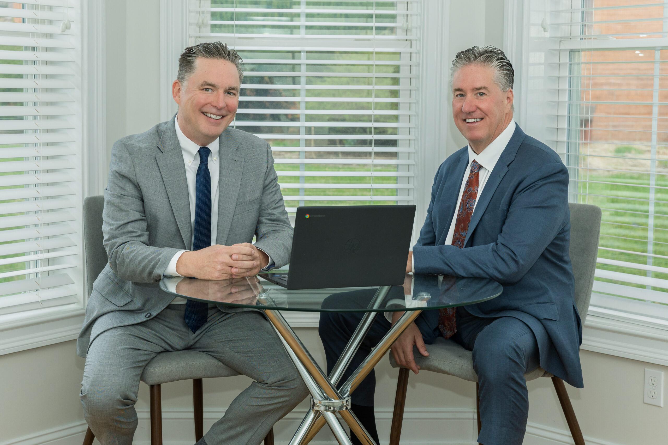 Attorneys Brian and Chris Flood discuss a case over a laptop