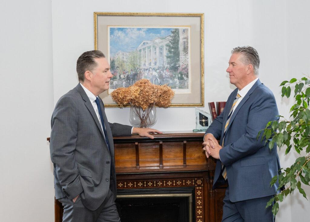 Attorneys Brian and Chris Flood discuss a case in office