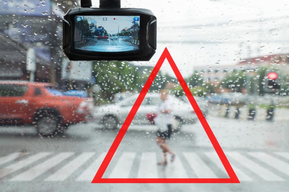 Stylized image of a dashcam recording a pedestrian in crosswalk, providing evidence for an accident
